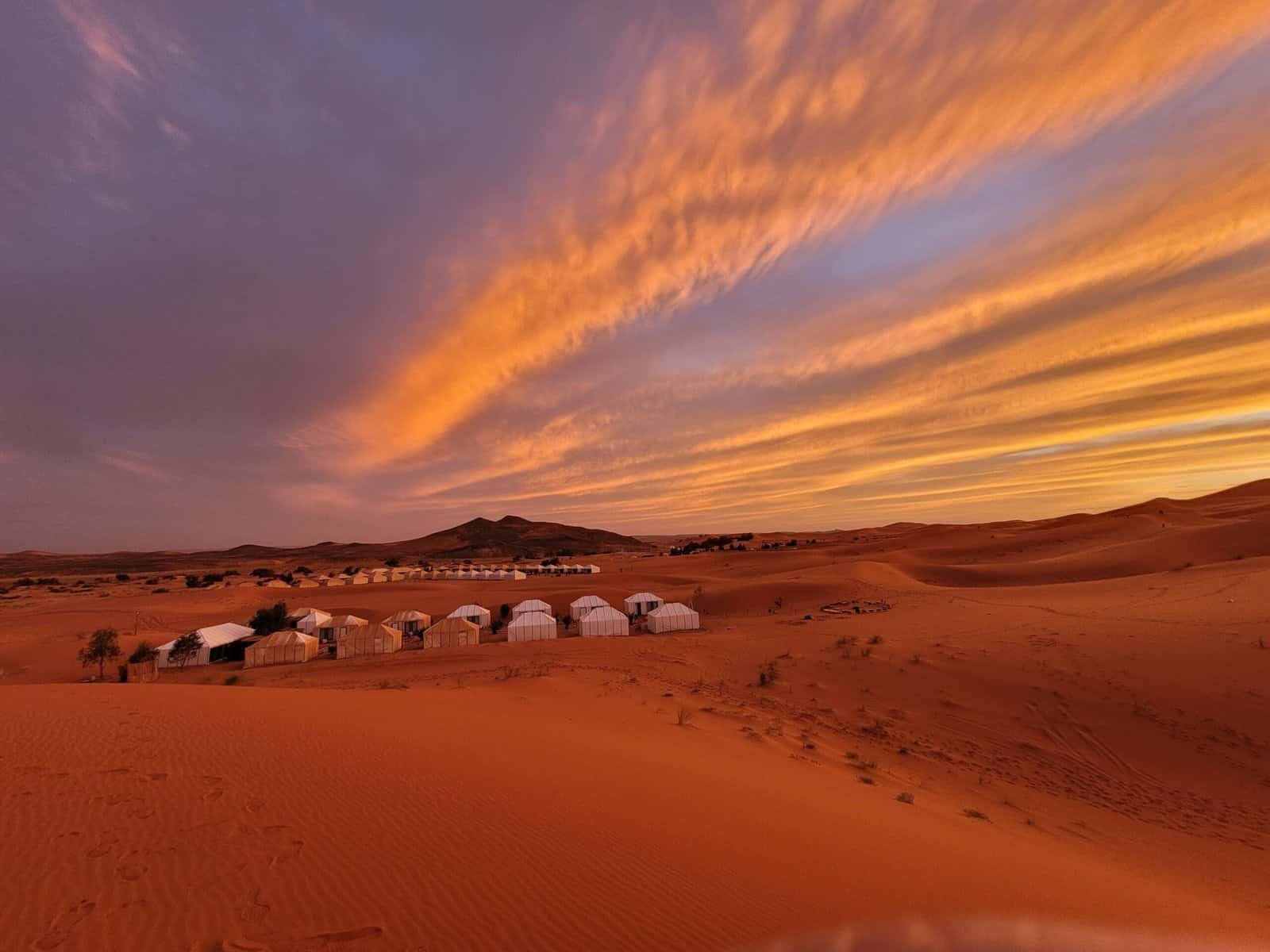 Desert camp among the dunes at sunset in Morocco